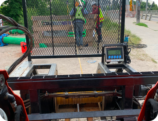 Close-up of pipe pulling equipment with digital tension gauge during trenchless pipe installation by Prima Pipe Solutions